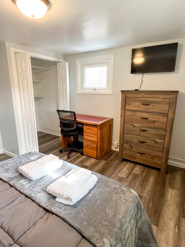 Bedroom with mounted TV and dresser