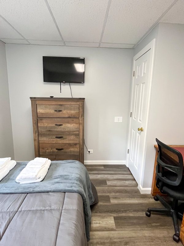 Bedroom with dresser and TV